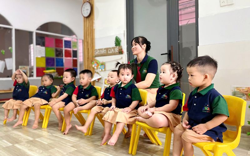 Các bé ngồi nghe cô kể chuyện